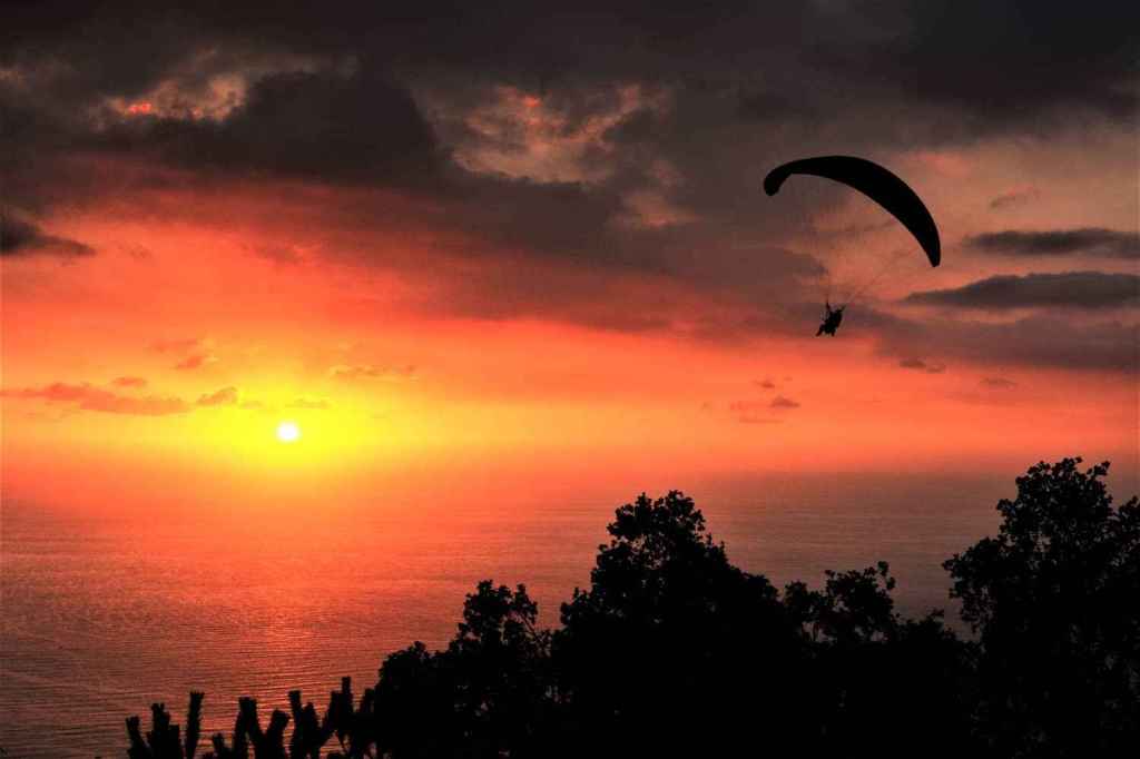 Person paragliding over Lebanese landscapes during a magnificent sunset with colourful skies