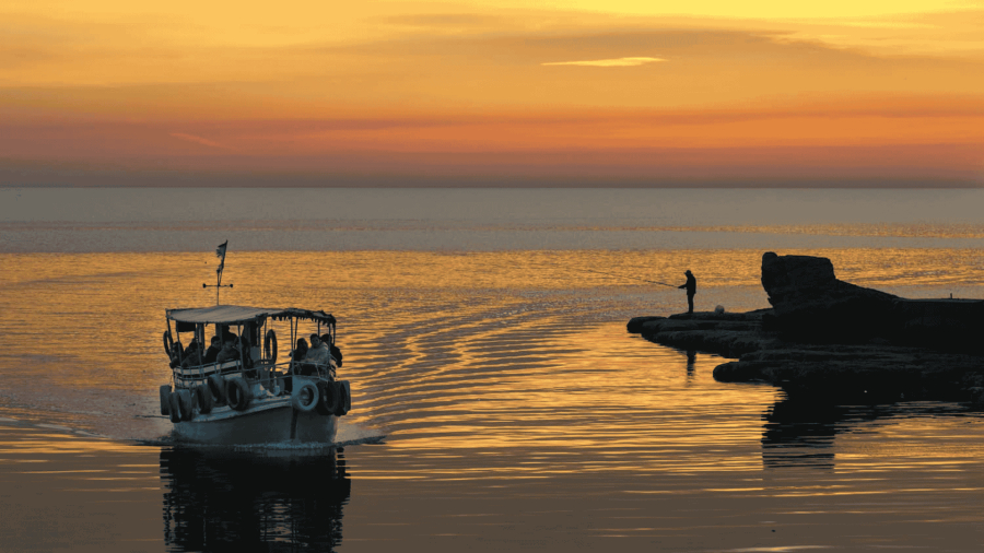 Sunset over the Byblos fishing port in Lebanon, with colorful skies and boats in the harbor